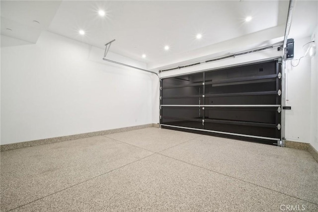 garage with recessed lighting and baseboards