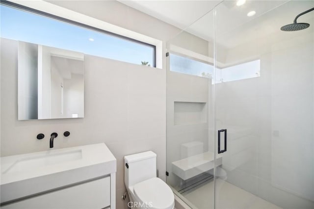 full bath with vanity, a shower stall, and toilet