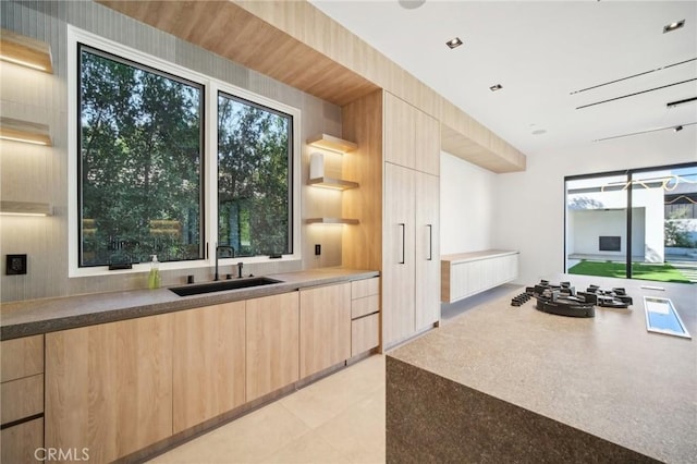 kitchen with modern cabinets, a sink, and light brown cabinetry