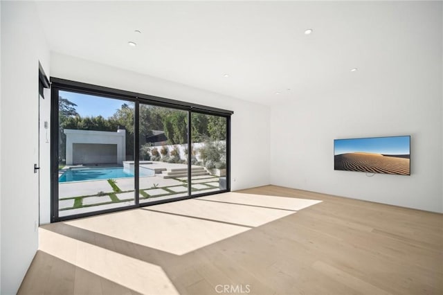 unfurnished living room with wood finished floors and recessed lighting