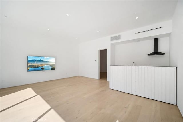 empty room featuring light wood-type flooring, visible vents, and recessed lighting