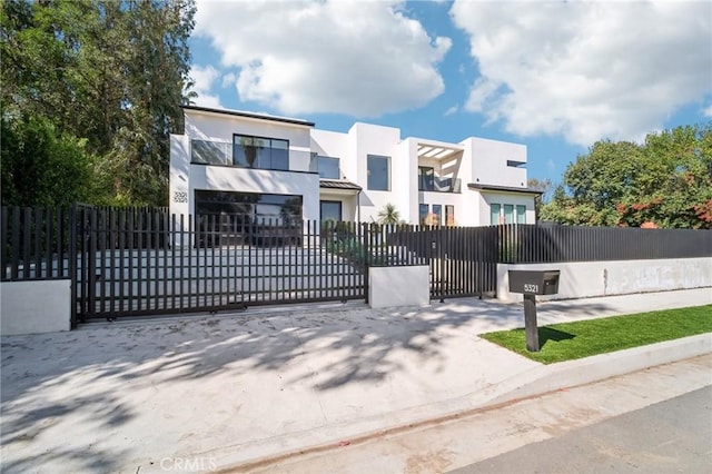 view of front of property featuring a fenced front yard, a gate, and stucco siding