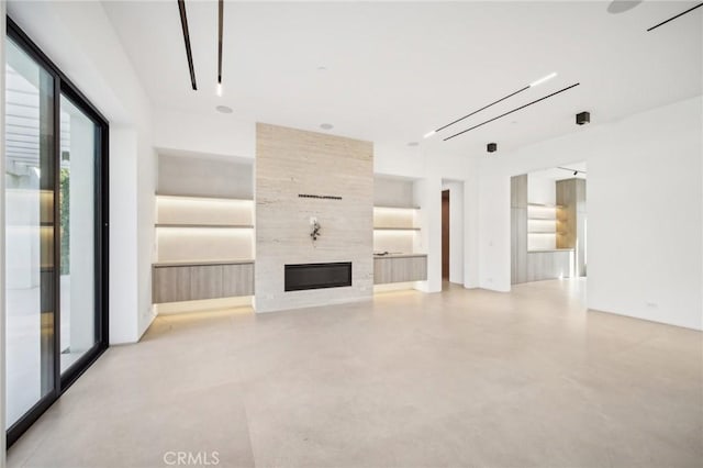 unfurnished living room featuring built in shelves, a tile fireplace, and finished concrete floors