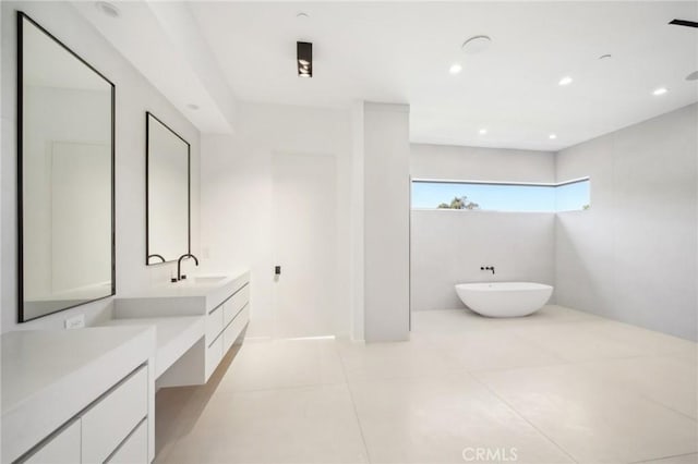 full bath featuring a freestanding tub, recessed lighting, tile patterned flooring, and vanity