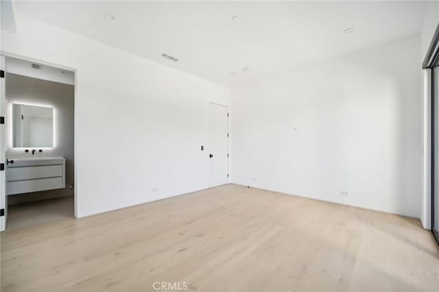 unfurnished bedroom featuring light wood-type flooring and visible vents