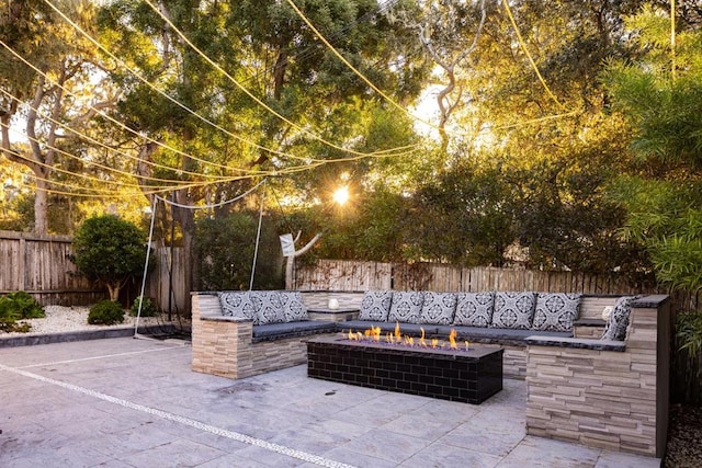 view of patio with an outdoor living space with a fire pit