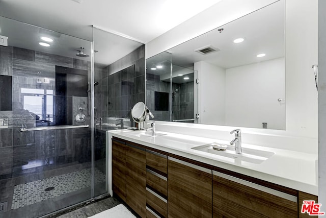 bathroom with vanity, a shower with shower door, and tile walls