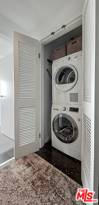 laundry room featuring stacked washer / drying machine