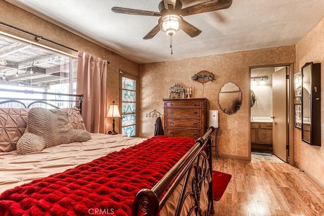 bedroom featuring ceiling fan, light wood-type flooring, connected bathroom, and a textured ceiling