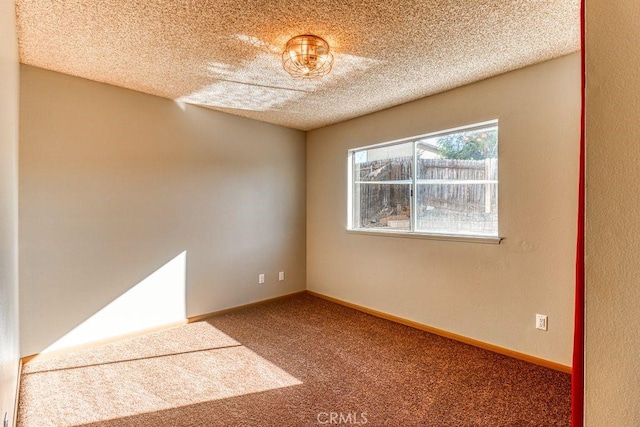 spare room featuring a textured ceiling and carpet