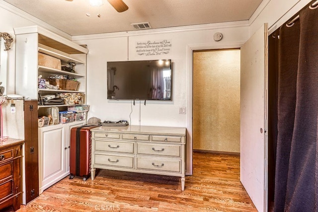 living room featuring ceiling fan, ornamental molding, and light hardwood / wood-style flooring