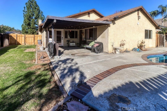 back of property featuring a patio and a lawn