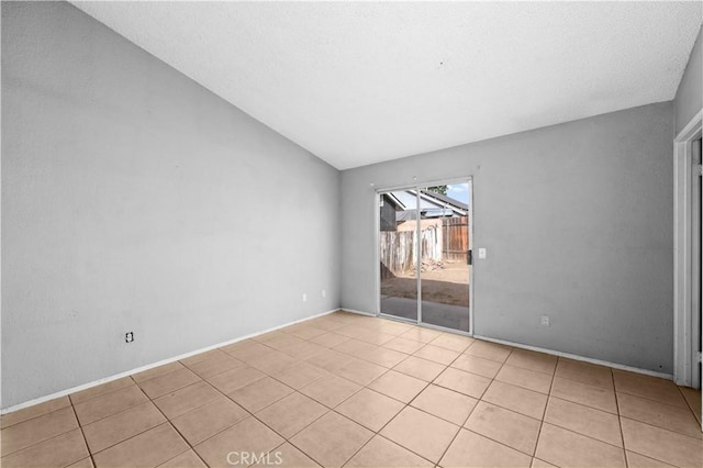 tiled spare room with vaulted ceiling