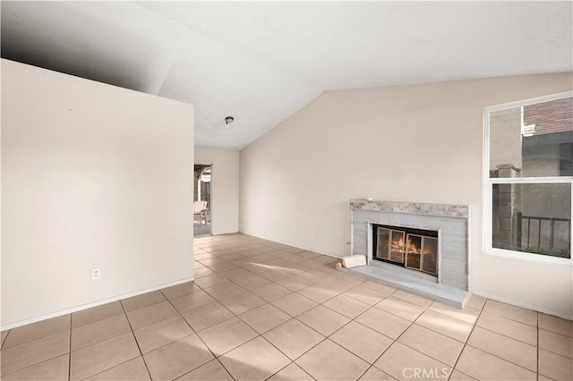 unfurnished living room featuring light tile patterned flooring, vaulted ceiling, and a premium fireplace