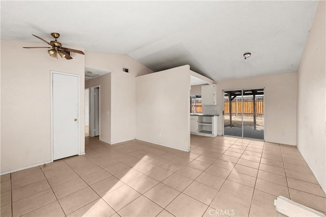 tiled empty room featuring vaulted ceiling and ceiling fan