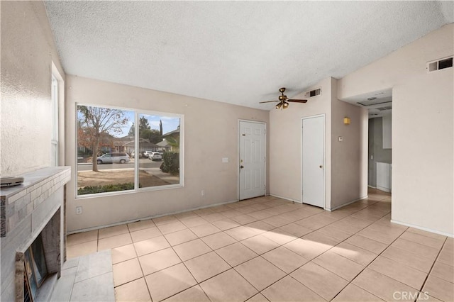 unfurnished living room with light tile patterned floors, a textured ceiling, ceiling fan, and lofted ceiling