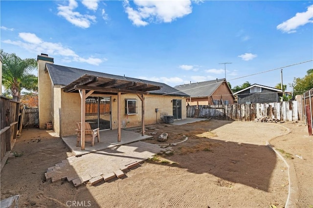 rear view of property featuring central AC unit, a patio area, and a pergola