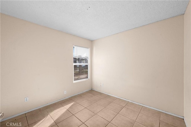 tiled spare room with a textured ceiling