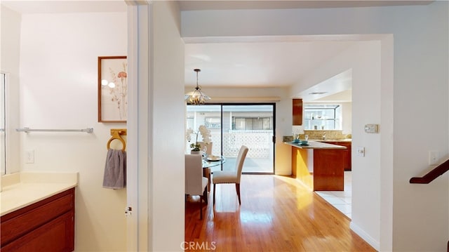 corridor featuring a notable chandelier and light hardwood / wood-style flooring