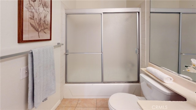 bathroom with shower / bath combination with glass door, tile patterned flooring, and toilet