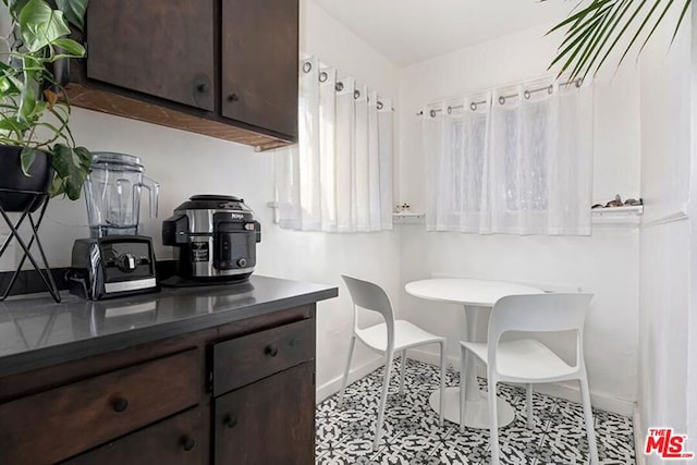 kitchen with dark brown cabinetry and light tile patterned flooring