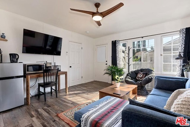 living room with ceiling fan and dark hardwood / wood-style floors