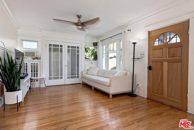 entrance foyer with crown molding, hardwood / wood-style floors, ceiling fan, and french doors