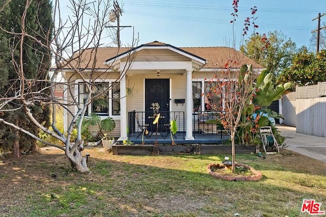 bungalow-style home with a porch and a front lawn