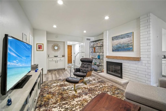 living room with light hardwood / wood-style flooring and a fireplace