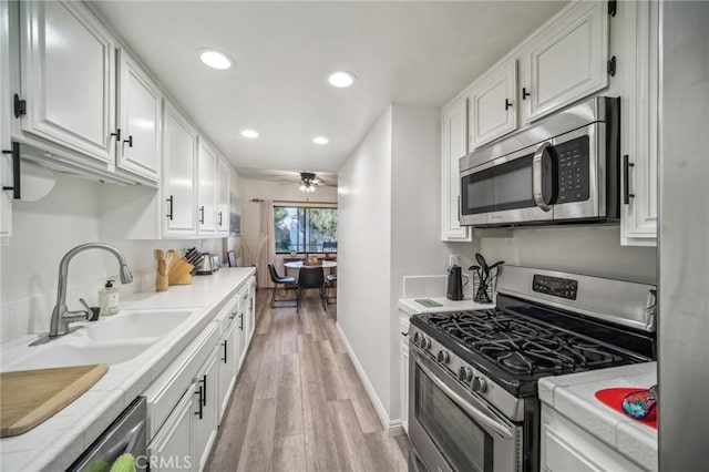 kitchen with sink, white cabinetry, and stainless steel appliances