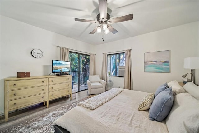 bedroom with ceiling fan, dark hardwood / wood-style floors, and access to outside