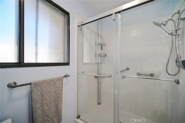 bathroom featuring a shower with shower door