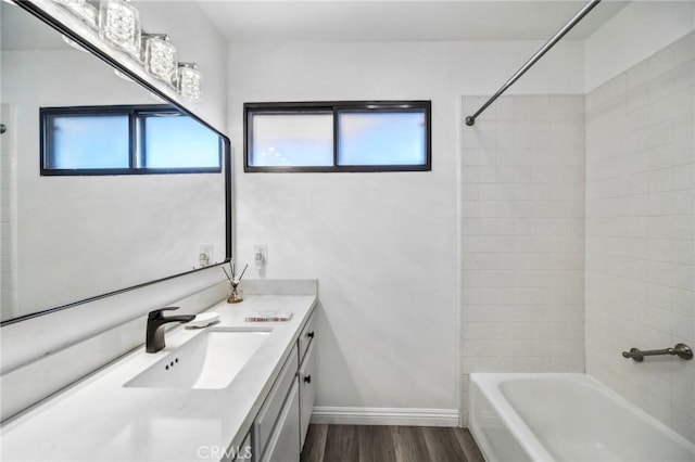 bathroom with tiled shower / bath combo, vanity, and hardwood / wood-style floors