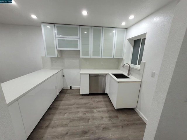 kitchen featuring dishwasher, white cabinets, light hardwood / wood-style floors, and sink