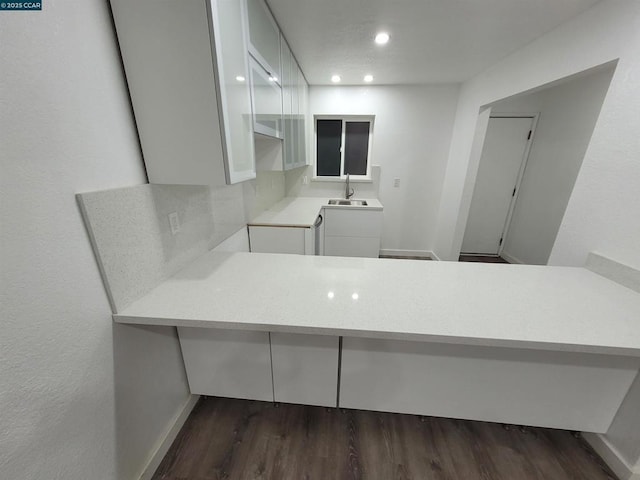 kitchen featuring white cabinetry, dark wood-type flooring, and sink