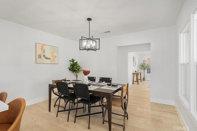 dining room featuring light wood-type flooring and a chandelier