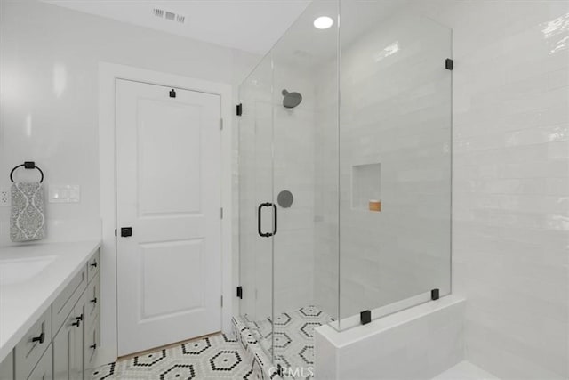 bathroom featuring vanity and a shower with shower door