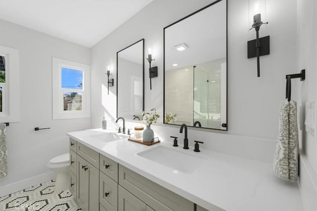 bathroom with tile patterned floors, vanity, a shower with shower door, and toilet