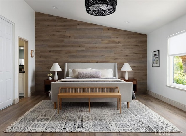 bedroom with hardwood / wood-style flooring, wooden walls, and vaulted ceiling