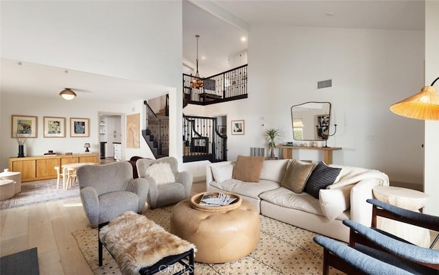 living room featuring light hardwood / wood-style flooring and high vaulted ceiling