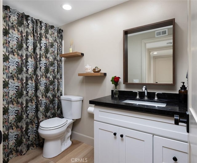 bathroom with vanity, toilet, and wood-type flooring