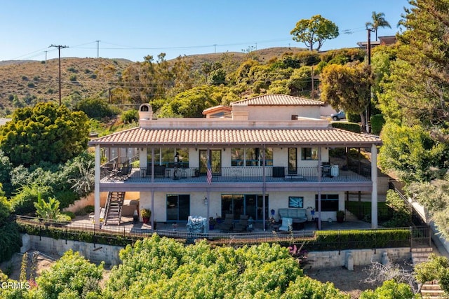 rear view of property featuring a balcony and a patio