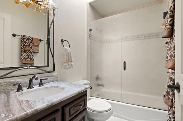 full bathroom featuring vanity, toilet, and bath / shower combo with glass door