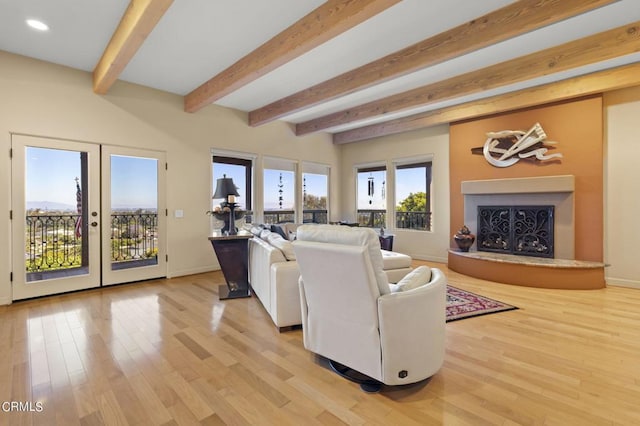 living room featuring light hardwood / wood-style floors, beam ceiling, and french doors