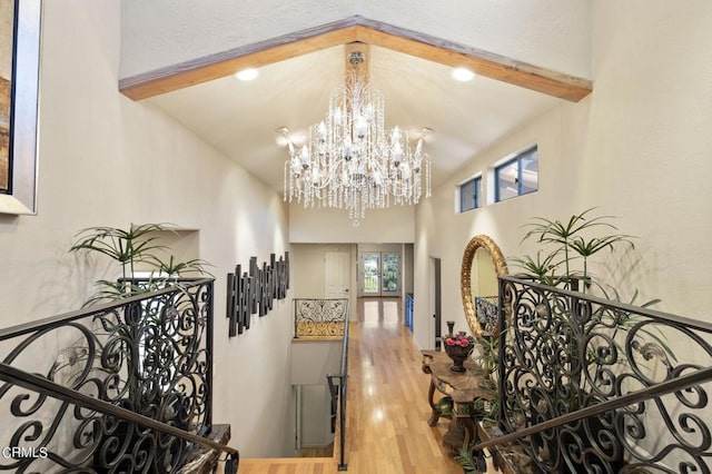 interior space featuring beam ceiling, hardwood / wood-style floors, high vaulted ceiling, and a notable chandelier