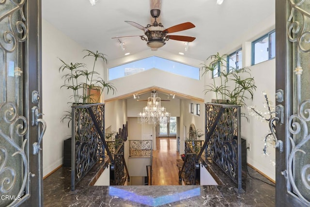 foyer featuring ceiling fan with notable chandelier