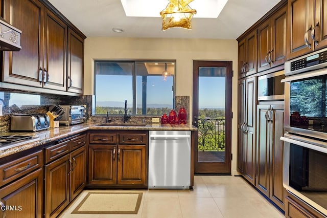 kitchen with ventilation hood, a wealth of natural light, sink, and appliances with stainless steel finishes