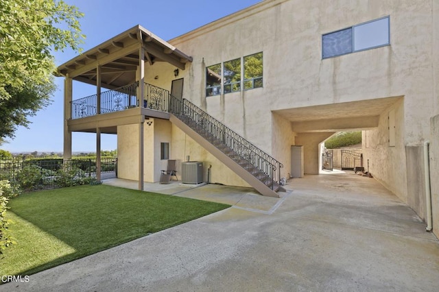 rear view of house featuring a patio area, a yard, and cooling unit