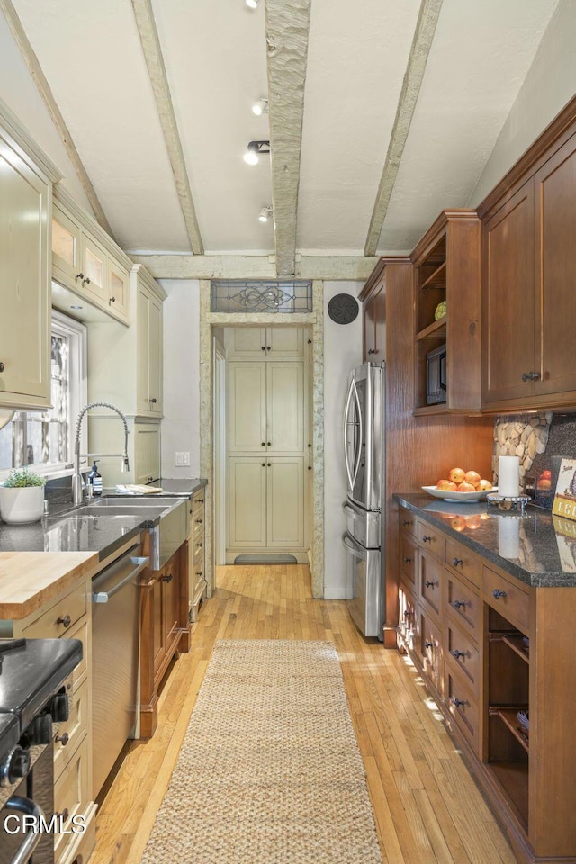 kitchen featuring butcher block counters, sink, light hardwood / wood-style flooring, stainless steel appliances, and cream cabinetry