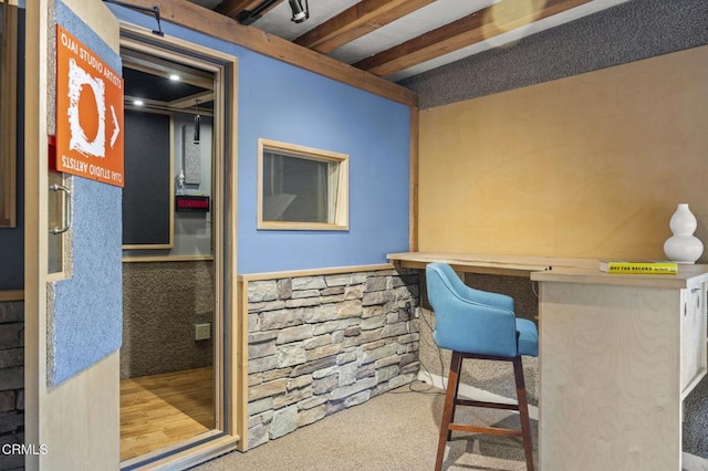 office area featuring beamed ceiling, carpet, and built in desk